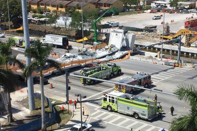 Nødetatene jobber på spreng etter at en gangbru kollapset over en motorvei i Florida torsdag. 