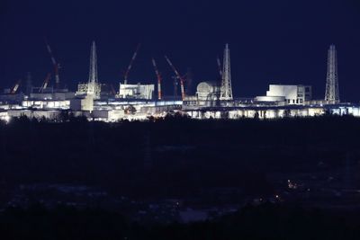 This March 10, 2018 picture shows the troubled Fukushima Daiichi nuclear power plant being lit up in Okuma, Fukushima prefecture, on the eve of the seventh anniversary of the 2011 Great East japan earthquake.
Japan marked on March 11 the seventh anniversary of a deadly earthquake, tsunami and nuclear disaster that devastated its northeastern coast and left about about 18,500 people dead or missing. / AFP PHOTO / JIJI PRESS / - / Japan OUT