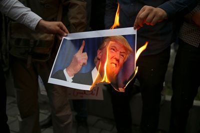 Demonstranter brenner et bilde av USAs president Donald Trump under en demonstrasjon foran USAs tidligere ambassade i Teheran, Iran, onsdag 9. mai i år, som en respons på Trumps beslutning om å trekke USA ut av den internasjonale atomavtalen og fornye sanksjoner mot landet.