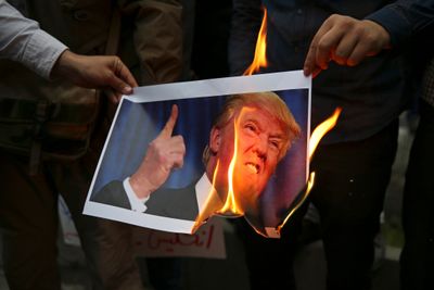 Demonstranter brenner et bilde av USAs president Donald Trump under en demonstrasjon foran USAs tidligere ambassade i Teheran, Iran, onsdag 9. mai i år, som en respons på Trumps beslutning om å trekke USA ut av den internasjonale atomavtalen og fornye sanksjoner mot landet.