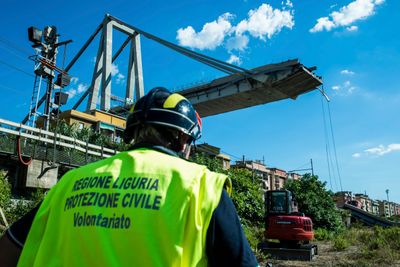 En arbeider inspiserer området rund Morandi-broen i Genova, som raste sammen tirsdag forrige uke.