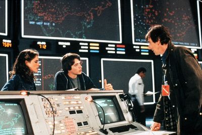 Scene fra WarGames-filmen med skuespillerne Ally Sheedy, Mathew Broderick og John Wood. I bakgrunnen sees noen av de store skjermene til WOPR-datamaskinen til NORAD.