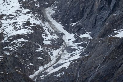 Steinstøv, grus og steiner ligger på snøen etter onsdagens steinsprang ved Veslemannen.