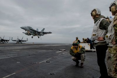 NATOs generalsekretær Jens Stoltenberg ser på mens et F-18 Super Hornet-fly lander på det amerikanske hangarskipet USS Harry S. Truman, som skal delta i NATO-øvelsen Trident Juncture.