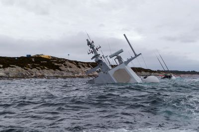 Den havarerte fregatten KNM Helge Ingstad fotografert onsdag 14. november. En amerikansk offiser som var om bord under havariet skal avhøres av politiet.