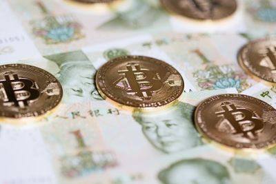 Bitcoins over the background made of Chinese yuan