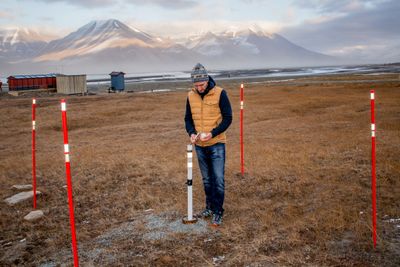 Forsker Graham Gilbert måler temperaturen i permafrosten i Longyearbyen. Temperaturmålere er utplassert i borehull i bakken en rekke steder på Svalbard og i andre arktiske områder.