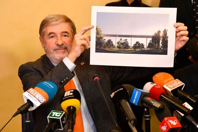 Genoa mayor Marco Bucci shows the rendering of the new bridge which will be realized by Salini, Fincantieri and Italfer during a press conference in Genoa, Italy, Tuesday, Dec. 18,  2018. The 202-million-euro ($229 million) project by hometown architect Renzo Piano inspired by a naval ship has been chosen to replace the Morandi Bridge that collapsed last summer, killing 43 people. (Luca Zennaro/ANSA via AP)