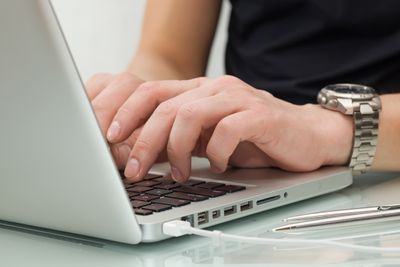 Businessman typing on a notebook (shallow DOF, hand in focus)