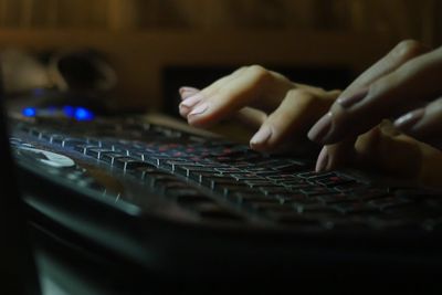 fingers of female on laptop, working late at night, blank blurred white screen as background, dark tone