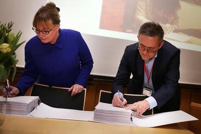 Visepresident Ellen White i Epic og styrelder Nils Kvernmo i Helseplattformen AS signerer kontrakten med Helseplattformen. Helseforetaket eies av Helse Midt-Norge.