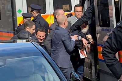 Britisk politi tvinger WikiLeaks-gründeren Julian Assange inn i en politibil utenfor Ecuadors ambassade i London. 