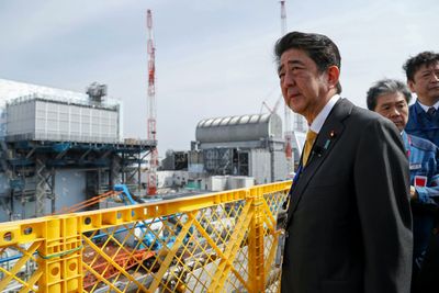Japans statsminister Shinzo Abe besøkte atomkraftverket i Okuma søndag. Her står Abe utenfor reaktor nummer 2 (til venstre) og nummer 3 (til høyre). (Photo by 