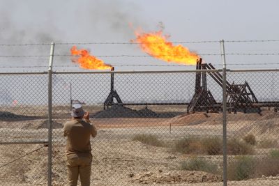 Illustrasjonsbilde: En journalist tar bilde av Exxons oljefelt West Qurna-1 nærme Basra 17. juni 2019.