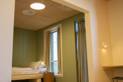Et av pasientrommene på akuttposten for psykiatri på Tønsberg sykehus. Rommet bader i varmt lys.