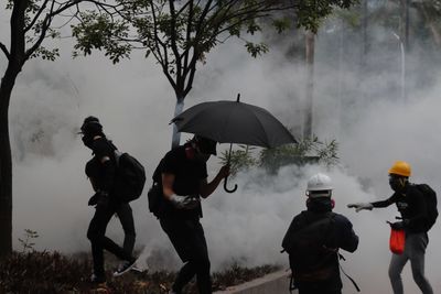 Politiet i Hongkong brukte søndag tåregass mot demokratiforkjempere som protesterte mot det nye forbudet mot ansiktstildekking.