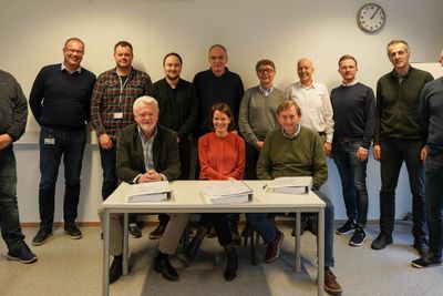 Fornøyde medarbeidere i Kraftmontasje bak administrerende direktør Oddgeir Anundsen og representanter for Skanska og Vegvesenet etter at kontrakten var signert.