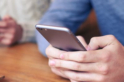 Cropped shot of people holding phone and texting