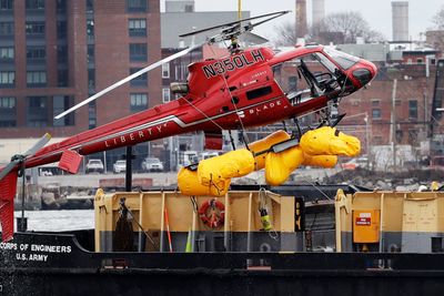 Ulykkeshelikopteret blir heiset opp på en pram dagen etter ulykken på East River i New York.