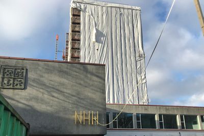 Norges handelshøyskole - med høyblokken innpakket for rehabilitering er så langt fornøyd med å være under Statsbyggs vinger.
