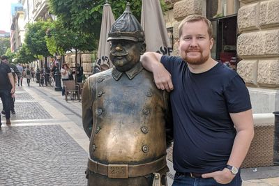 David Kristensen er seniorkonsulent i Forse. Her under en jobbtur til Budapest i 2019. Statuen til venstre er angivelig av en politimann.