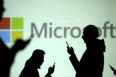 FILE PHOTO: Silhouettes of mobile users are seen next to a screen projection of Microsoft logo in this picture illustration taken March 28, 2018.  REUTERS/Dado Ruvic/Illustration/File Photo/File Photo