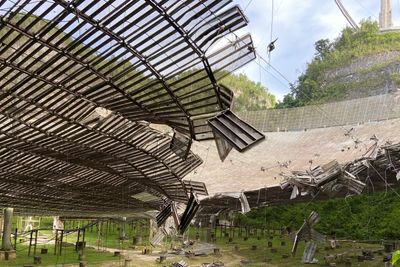 Et bilde tatt i august viser skadene en ødelagt kabel har gjort på antennen på Arecibo-observatoriet på Puerto Rico. Nå står radioteleskopet i fare for å kollapse.