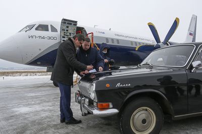 Panseret på en GAZ-24 Volga brukes som skriveunderlag etter den første flygningen med Il-114-300.