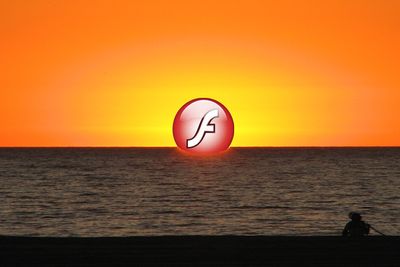 Logoen til Adobe Flash Player forsvinner ned i havet. Illustrasjonsfoto.