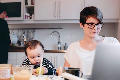 Woman working from home with child.