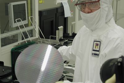 Det er svært mye som skjer i halvlederbransjen for tiden, etter en rekke relativt kjedelige år. På bildet viser en Intel-ansatt fra en wafer, en silisiumskive som det lages mikrobrikker av.