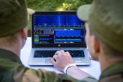 To kandidater jobber med en spektrumsanalysator, et instrument som er viktig i elektronisk krigføring.  