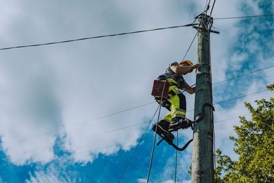 Montør klatrer i gammel telefonstolpe. Telenor er i gang med å fjerne en halv million gamle telefonstolper, men må kanskje bruke litt lengre tid enn de ønsker på å gjøre jobben. 