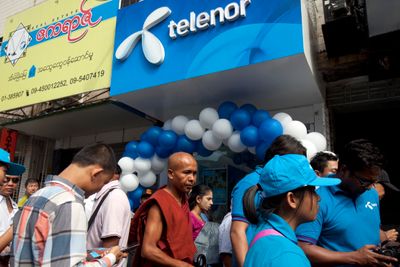 I 2014 stod folk i kø utenfor denne Telenor-butikken i Myanmar. Nå skriver et myanmarsk opposisjonsnettsted at Telenor har gitt regimet sensitive opplysninger om mobilkunder og mobilbruken deres.