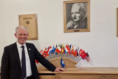 FFIs tidligere direktør John-Mikal Størdal leder Nato Science & Technology Organization i Paris. På veggen bak henger et bilde av grunnleggeren, dr. Theodore von Kármán, som etablerte organisasjonen for 70 år siden.