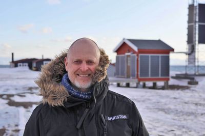 Christian Skottun, her foran en av basestasjonene på Svalbard. Allerede i 2019 tok Telenor Svalbard solenergi i bruk ved flere av sine basestasjoner for å redusere bruken av fossil energi. 