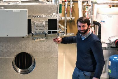 Forskningsleder Alexis Sevault foran det termiske batteriet som nå er installert i ZEB-laboratoriet til Sintef. Enheten dekker varmebehovet for bygget på 2000 kvadratmeter i opptil tre dager. 