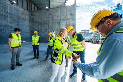 Miljø og prosessingeniør Lise Gunn Storeheier Karlsen og driftssjef Fredrik Johnsen viser frem glasset som vil brukes til isolasjon.