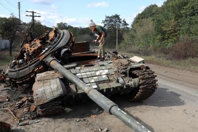 Ei jente studerer ei ødelagt russisk stridsvogn i landsbyen Oskol i Kharkiv 9. oktober.