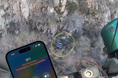 Bilvrak nede i en canyon i Los Angeles County, sett fra et redningshelikopter som har blitt varslet via satellitt av bilførerens Iphone 14. Dette kan både gjøres av brukeren selv eller utløses automatisk av en kollisjonsdetektor i mobilen.