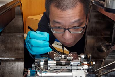 Her monterer forsker Dong Wang en mikrostrekkmaskin i et skanningelektronmikroskop. Dette kan registrere sammenhengene mellom spenning og tøyning, som er viktig for å forstå oppførselen til et materiale, ikke minst hvordan hydrogen påvirker egenskapene. Hele forløpet dokumenteres med både bilder og video, så kan forskerne teste med og uten hydrogen, og se forskjellene.