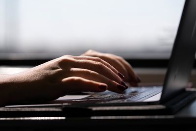 FILE - This May 18, 2021, photo shows a woman typing on a laptop on a train in New Jersey.  Scams ar ...