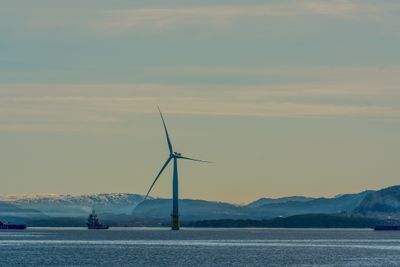 Et idyllisk bilde av en vindturbin på havet. 