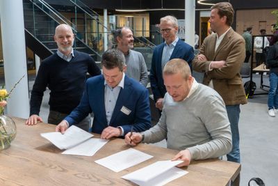 Senioringeniør Håkon Eyde Kjuus i Forsvarsmateriell og administrerende direktør Eivind Helgaker i Ice signerer samarbeidsavtale under påsyn av fornøyde medarbeidere fra Ice og Forsvarsmateriell.