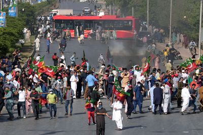 Tilhengere av Pakistans tidligere statsminister Imran Khan kaster stein mot politiet under en protest mot arrestasjonen av Khan i Karachi i Pakistan tirsdag. 