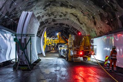 Tunnelelementene på fem tonn transporteres fra Drammen havn, og den nye elektriske anleggsmaskinen bruker vakuum for å suge dem fast før de settes forsiktig på plass på bolter inne i tunnelen. 