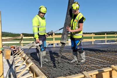 Jørgen Owren Furuli, til venstre, og Even Ellevold støper med betong tilsatt kull. De sier støpbarheten er som vanlig betong, kun fargen skiller seg ut.