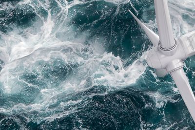 Aerial panorama of a close up wind turbine on the ocean