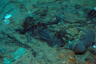 Rester av en frakk og støvler på havbunnen i nærheten av Titanic-vraket. Letingen etter ubåten Titan, som var på vei ned til vraket, er særdeles vanskelig, forteller eksperter.