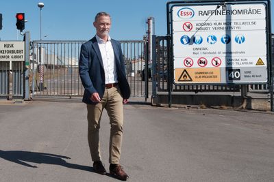 Øyvind Rudberg foran et inngangsskilt til Slagentangen som snart kan få et tillegg om produksjon av hydrogen og ammoniakk.